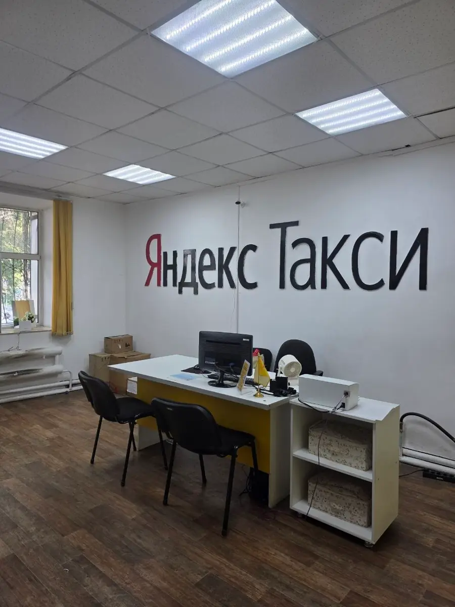 офис таксопарка в Семее с логотипом Яндекс Такси на стене